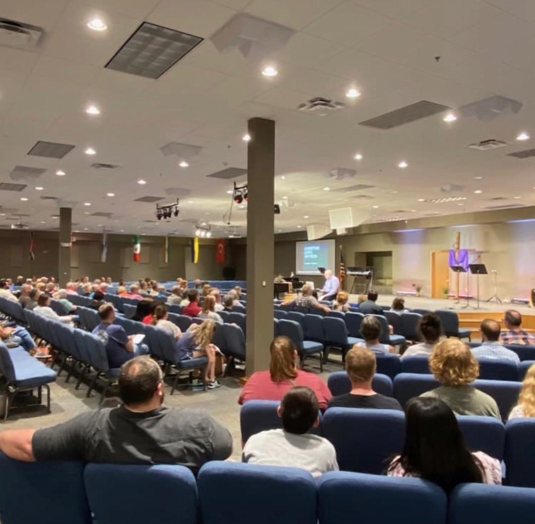 Pastor John teaching to a full sanctuary